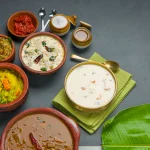 kerala-traditional-feast-side-dishes-arranged-two-color-background-with-fresh-banana-leaf_527904-220