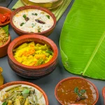 kerala-traditional-feast-side-dishes-arranged-two-colour-background-with-banana-leaf-serving-food_52